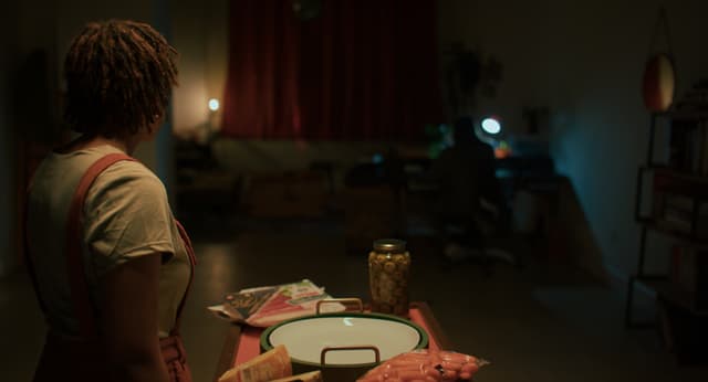 A woman looks away from camera in moody lighting