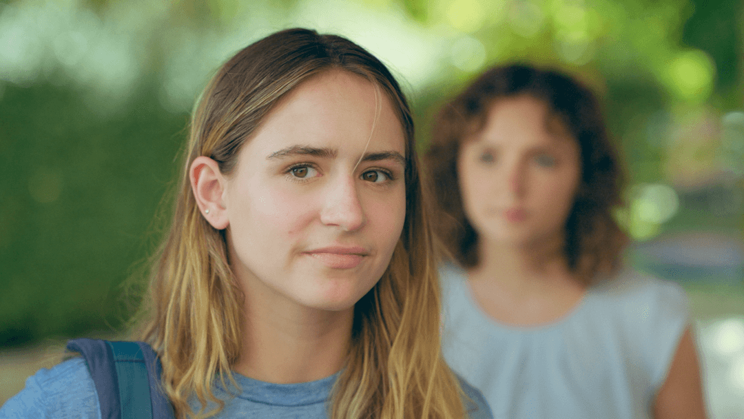 Kate and her friend talk at a cafe