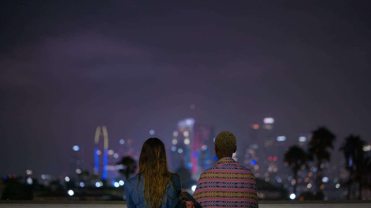 Two women look off into the distant LA skyline.